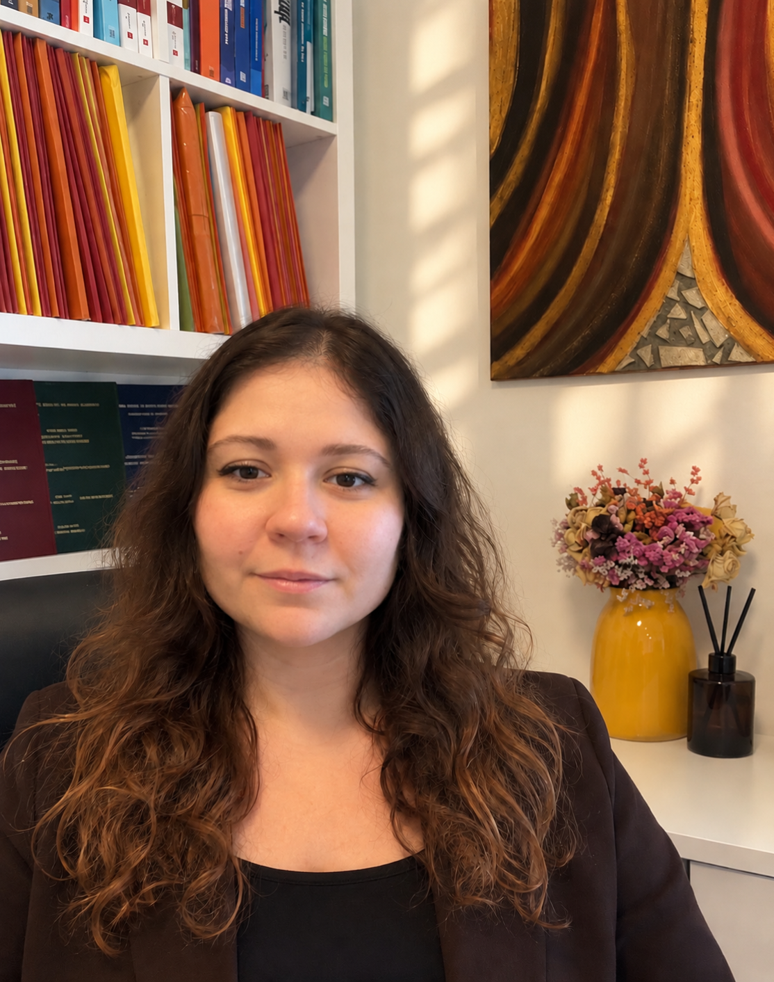 Camilla Raggi nel suo spazio di lavoro, davanti alla libreria